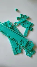 Green cast-on comb parts laid out on a table