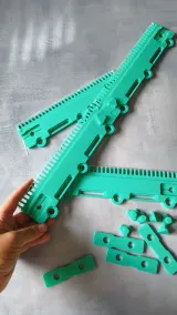 Assembled green cast-on comb held in hand
