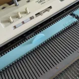 Mint green assembly stop ruler in use on a standard gauge needle bed
