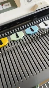 Pastel needle markers with arrows on a Brother 5gg knitting machine needle bed