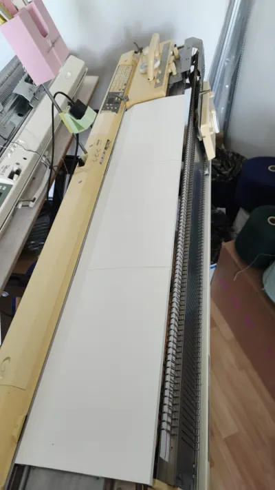 White magnetic needle bed cover on a Brother 3GG (9mm) bulky knitting machine
