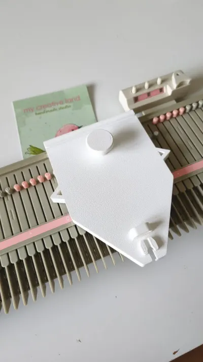 White 3D-printed unraveling carriage on a Silver Reed LK150 needle bed